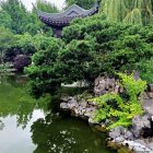 Tranquil watercolor painting of Asian-style pavilion by serene pond