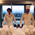 Elderly people celebrating indoors with cake and city view