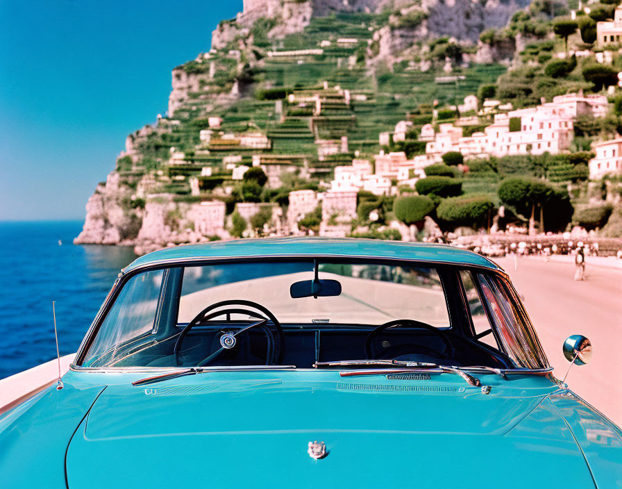 Vintage Blue Car on Coastal Road with Cliffside Town and Mediterranean Sea View