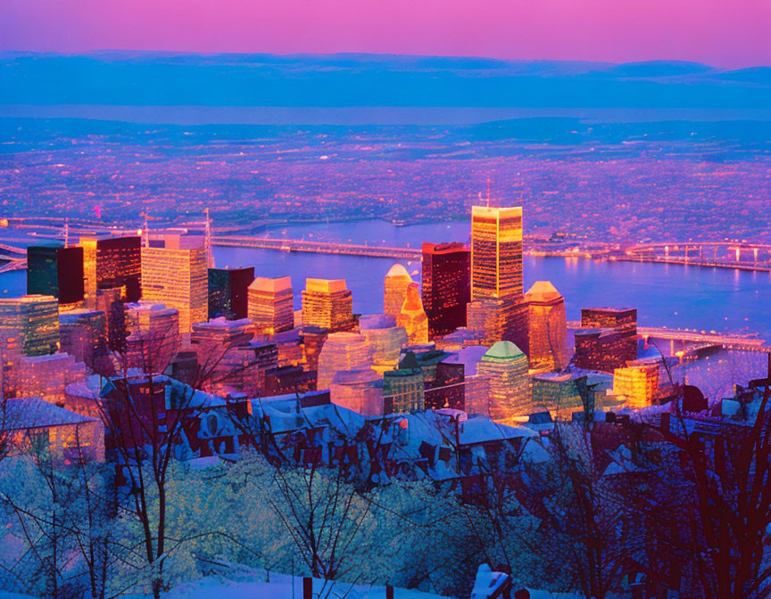 City skyline at dusk with illuminated buildings, river view, snowy hills, purple sky