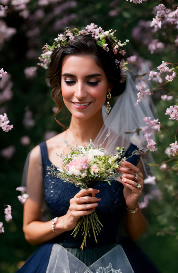 Bride in Navy Blue Dress with Floral Crown and Bouquet among Pink Blossoms