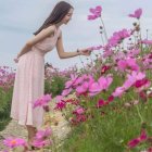 Woman in floral dress admiring flowers in colorful field