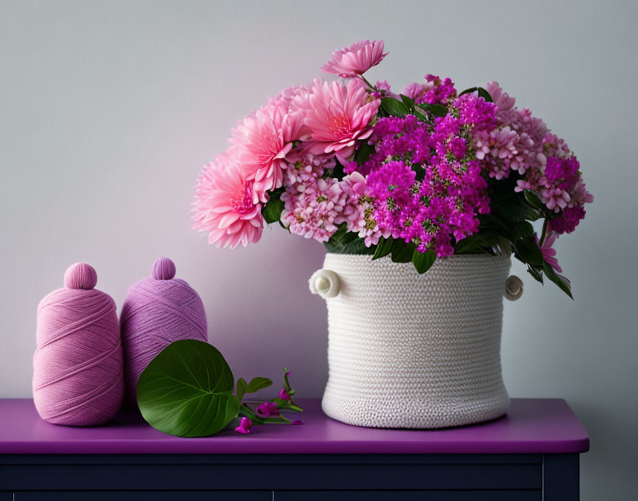 White Woven Basket with Pink Gerberas and Lilac Flowers on Purple Table