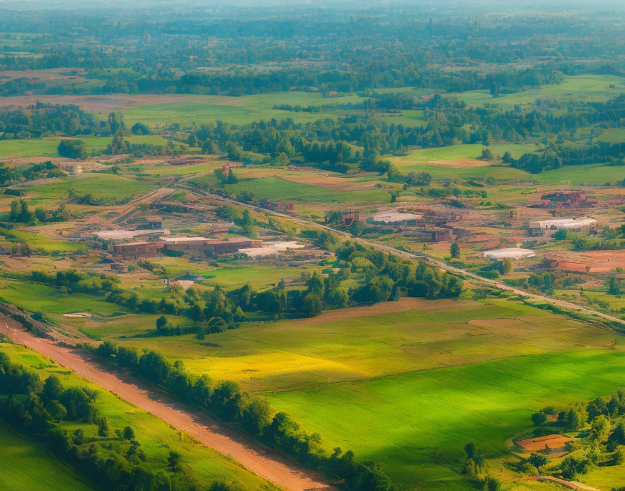 Vibrant green rural landscape with dirt roads and scattered buildings