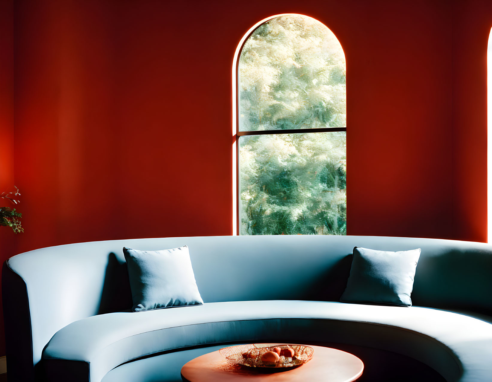 White Curved Sofa with Blue Pillows Against Red Wall and Arched Window