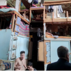 Woman and child in colorful shop with shelves, observed by two people outside