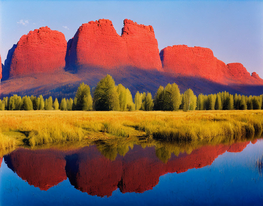 Majestic red rock formations by a serene lake in lush green landscape