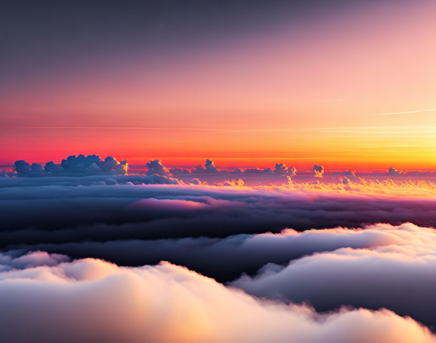 Vibrant pink and orange sunset cloudscape with fluffy silhouetted layers