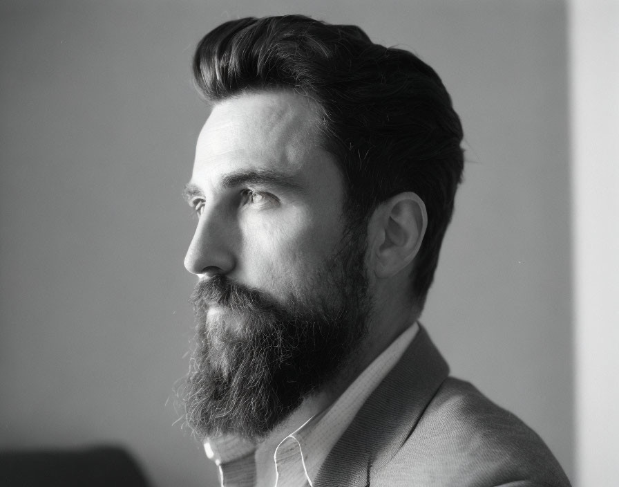 Monochrome side portrait of bearded man in suit with thoughtful expression