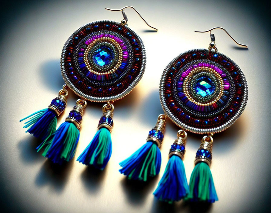 Circular Beaded Earrings with Blue Tassels and Reflective Surface