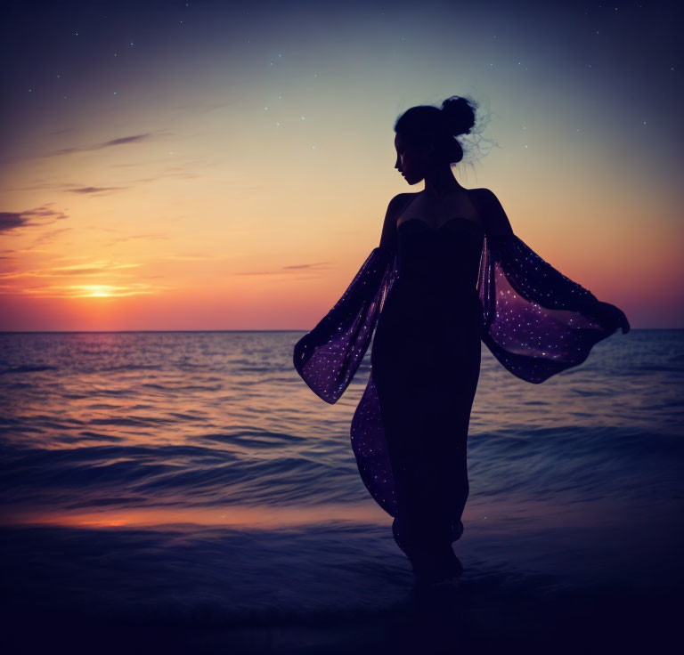 Woman's silhouette on beach at sunset with flowing dress and starry sky