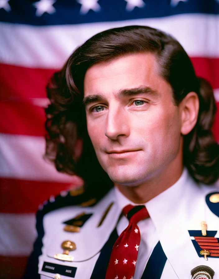 Decorated military man in front of American flag with serious expression