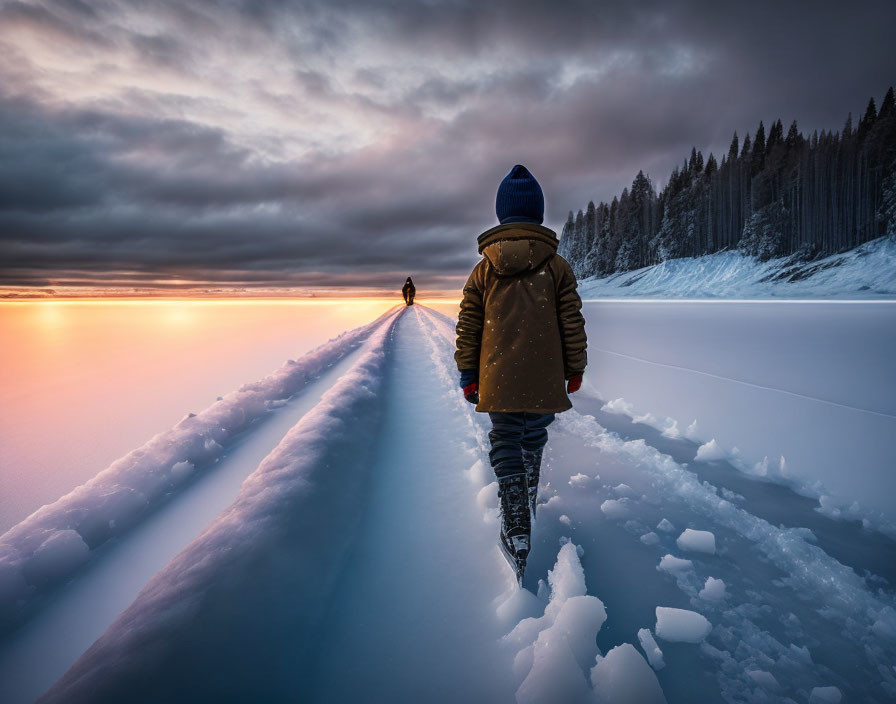 Person in warm jacket walking on snow-covered path under dramatic winter sky