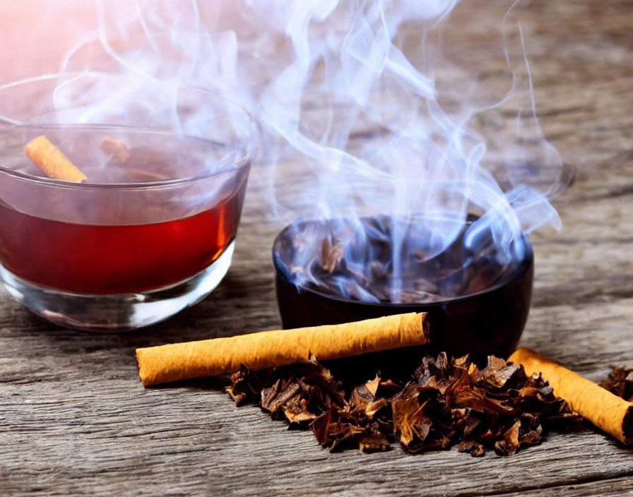 Hot tea and smoldering spices on wooden table