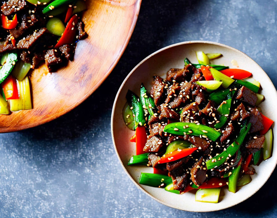 Asian-style Beef Stir-Fry with Vegetables and Sesame Seeds on Dark Countertop