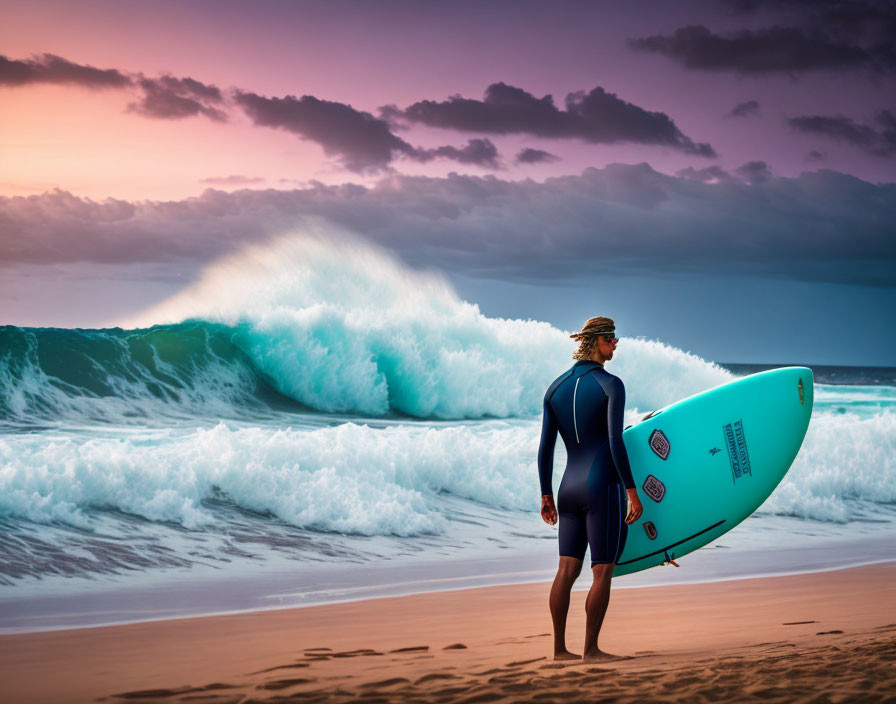 Surfer in wetsuit with blue surfboard at sunset beach.