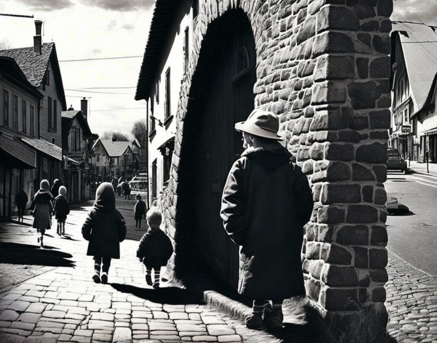 Monochrome photo: Person in coat and hat watching children on old street