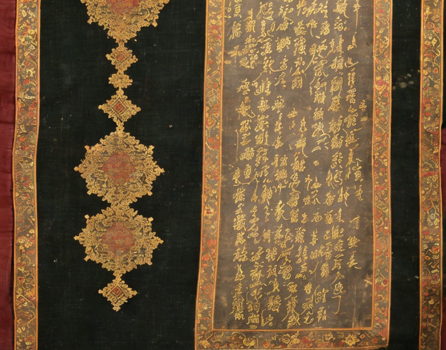 Intricate golden embroidery on antique fabric with Asian script and decorative borders on dark background