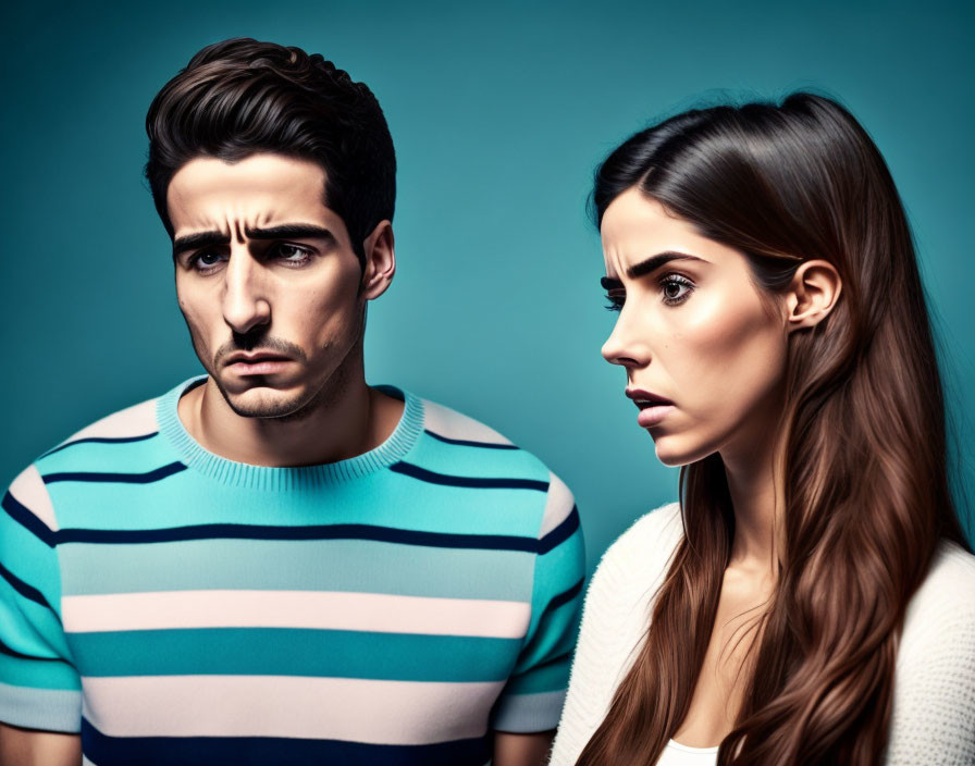 Young man and woman with expressive faces on teal background