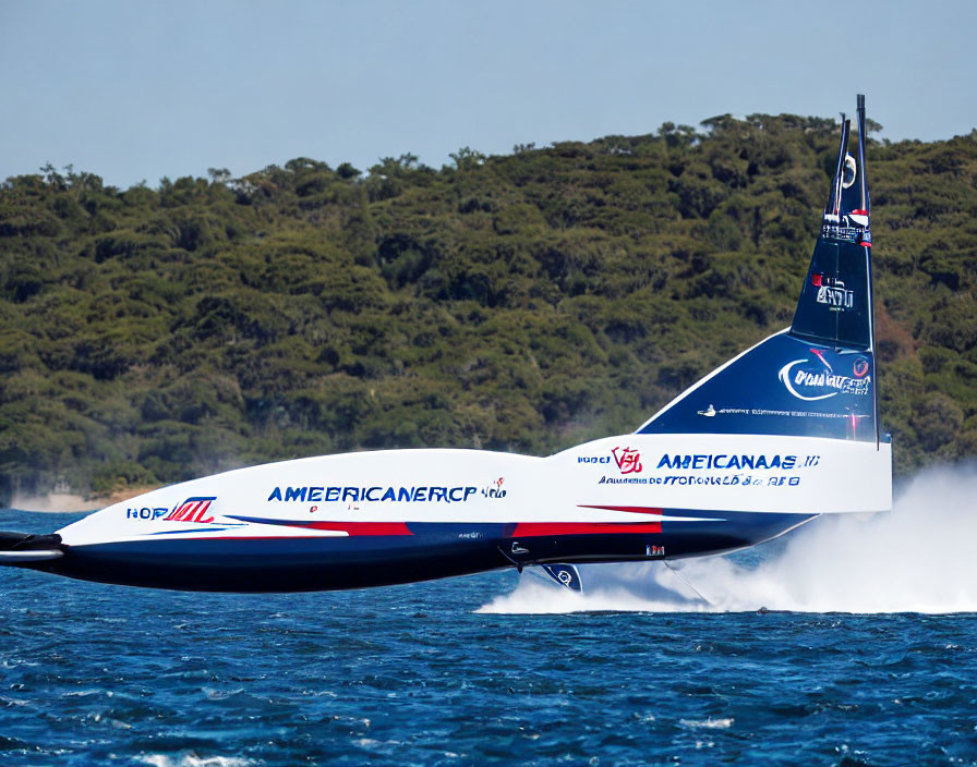 Hydrofoil sailing boat with "American Magic" branding gliding above water