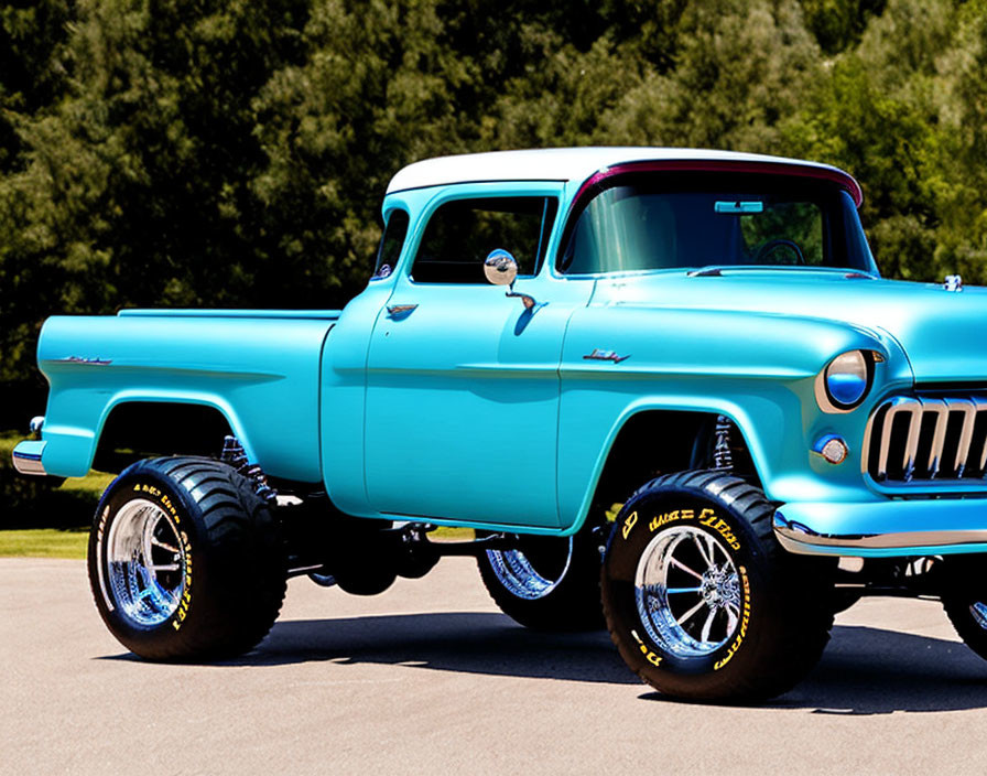 Vintage blue pickup truck with oversized wheels and raised suspension parked outdoors