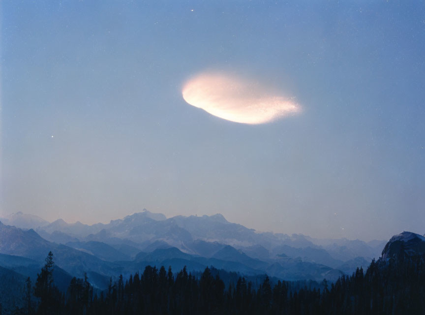 Lenticular Cloud Over Forested Mountains at Twilight