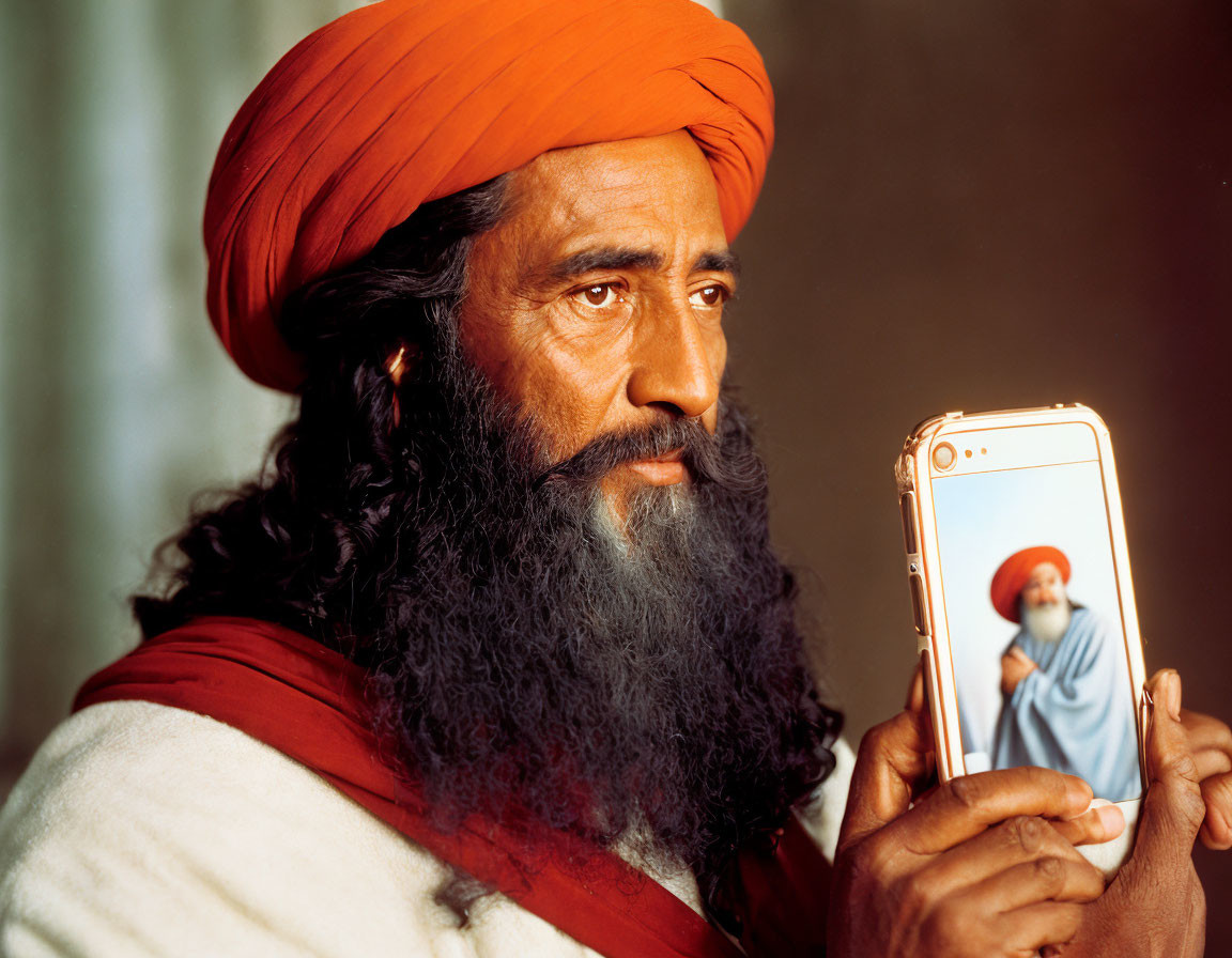 Bearded man in turban with smartphone displaying self-portrait