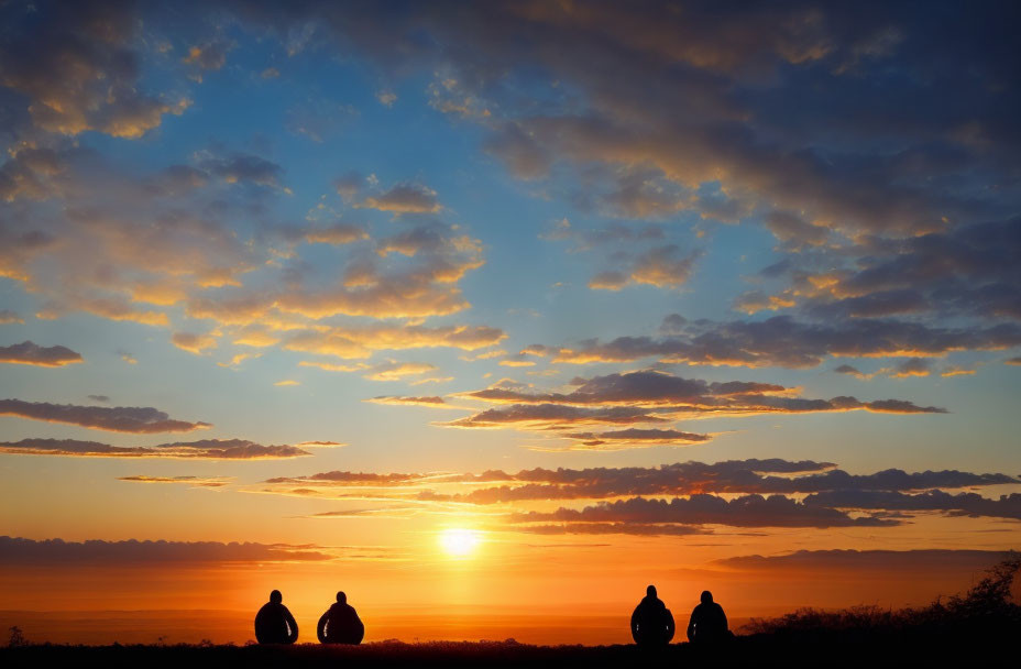 Silhouetted figures against vibrant sunset with blue and orange hues