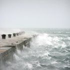 Dramatic tall ships on tumultuous seas with towering waves