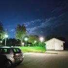 Starry night with moon, SUV, house, and street lamps