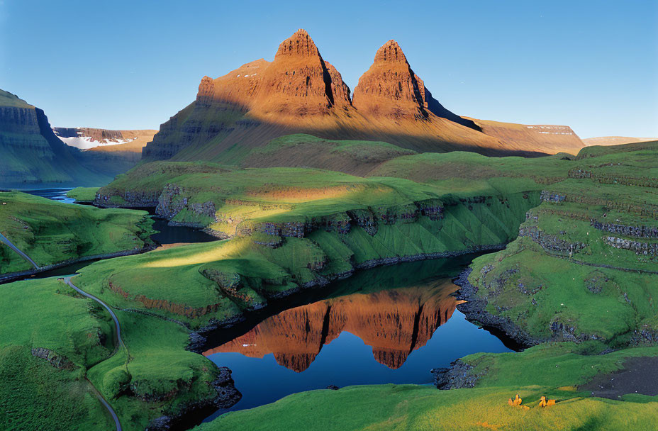 Sunlit Peaks Reflected in Calm Lake Amid Green Slopes