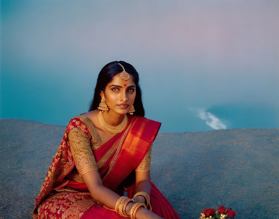 Traditional Indian Attire Woman Sitting Against Blue Backdrop