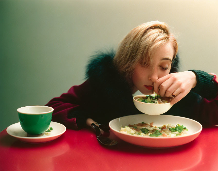 Person Eating at Table with Bowl, Cup, and Plate