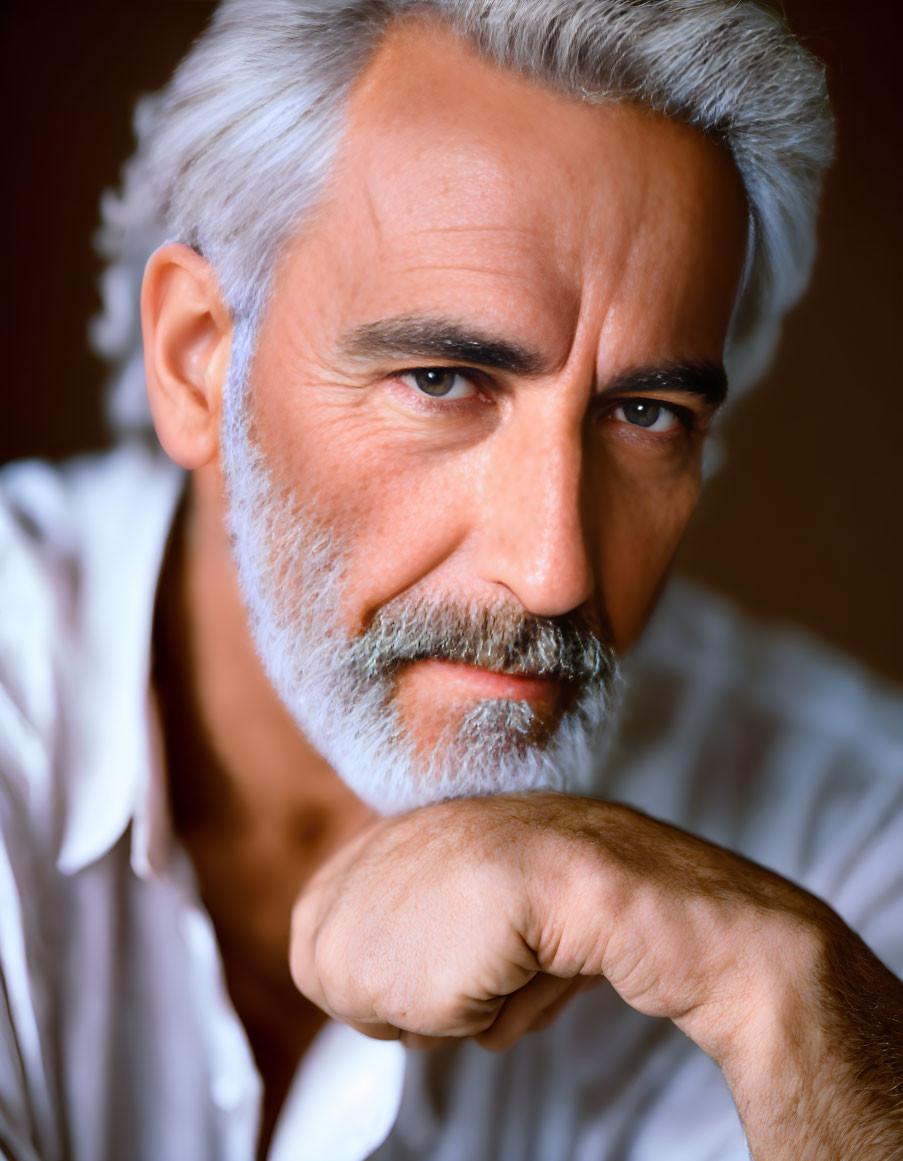 Distinguished older man with salt-and-pepper hair and beard in white shirt portrait