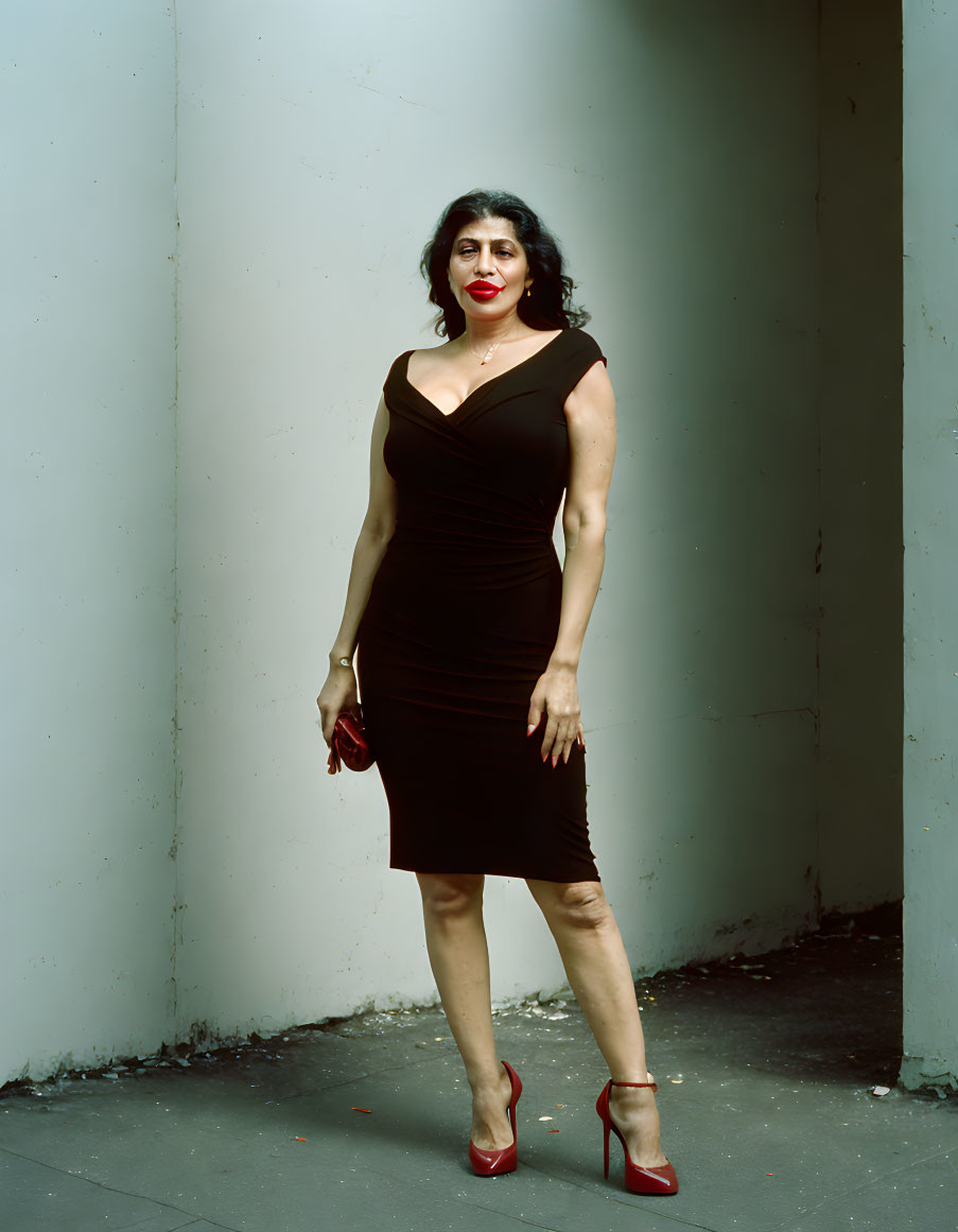 Woman in Black Dress and Red Heels Against Two-Tone Wall