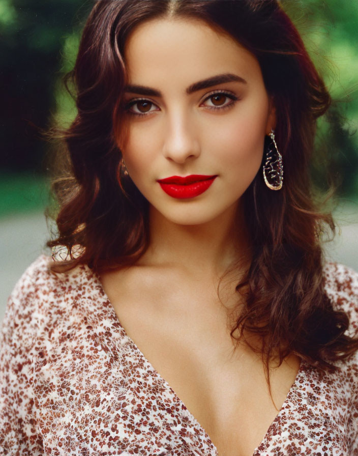 Woman with long brown hair in leopard print top and red lipstick against green background