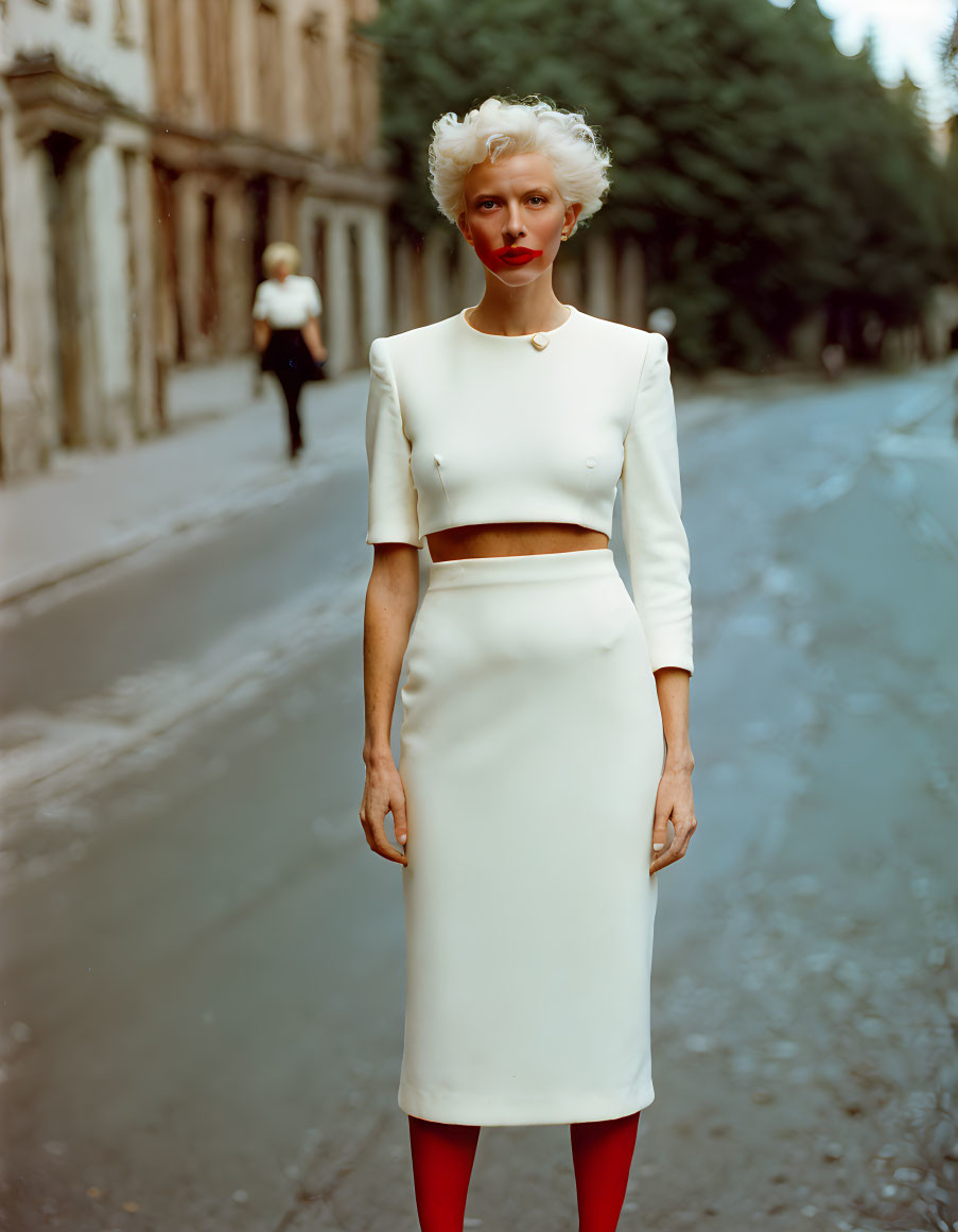 Platinum blonde woman in white dress on cobblestone street