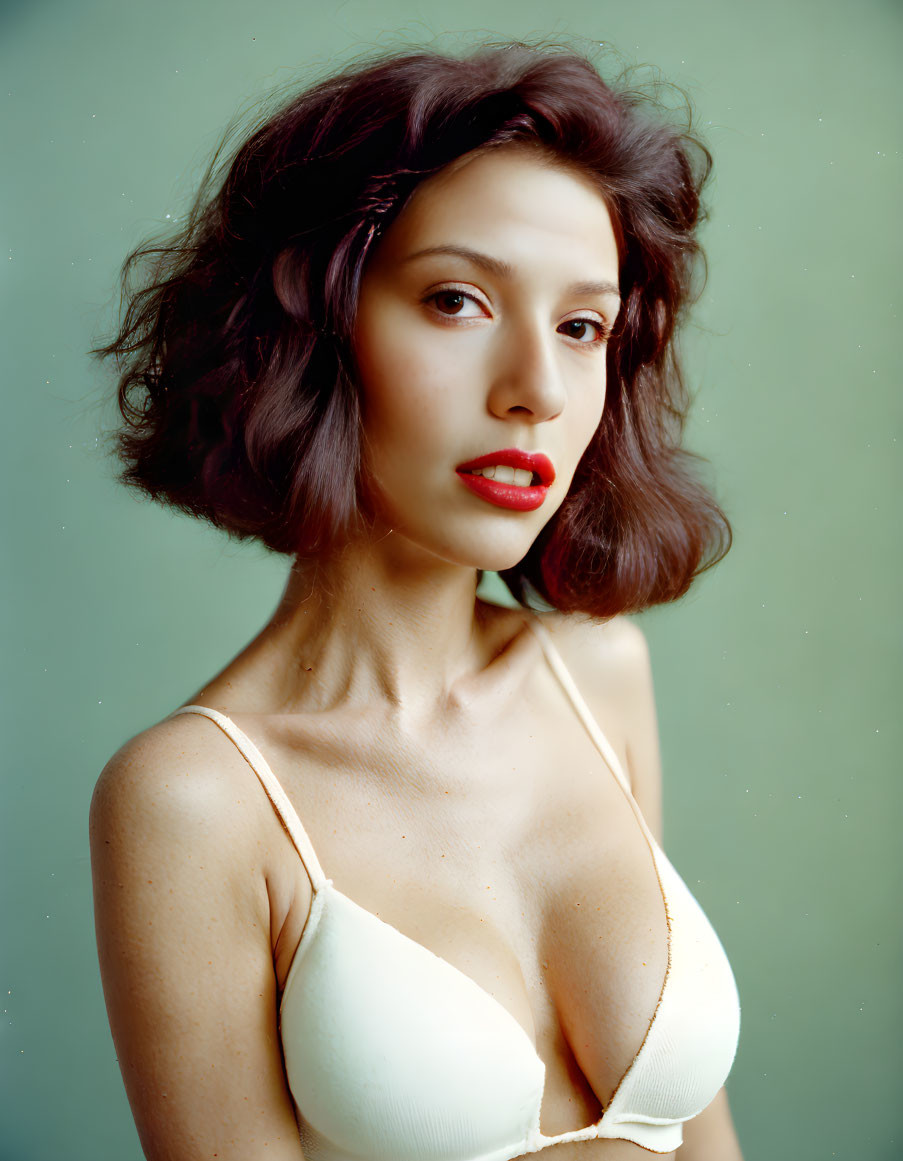 Woman with Red Lipstick and Brown Hair in Beige Top on Green Background