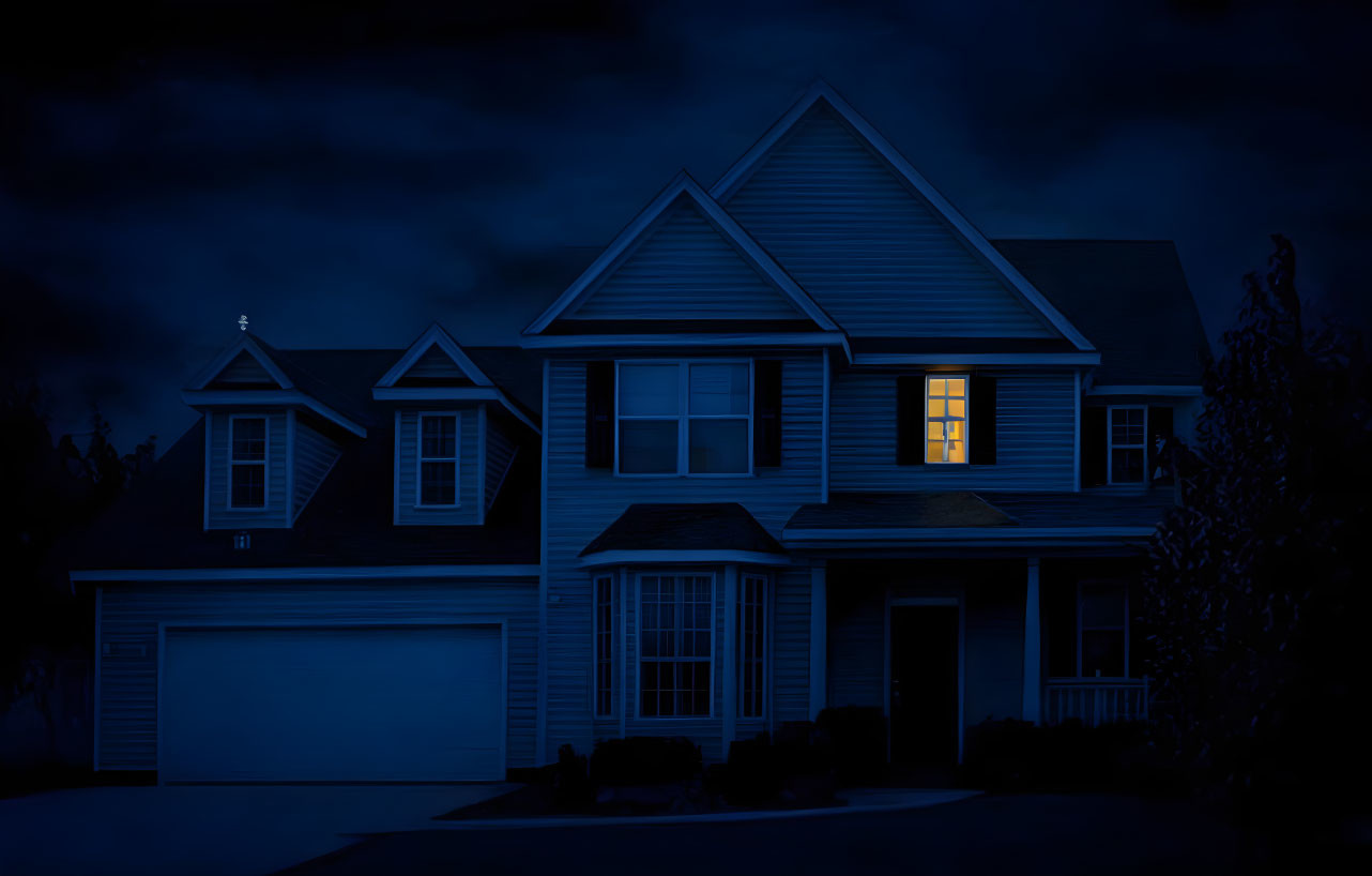 Suburban House Night Scene with Blue Hue and Illuminated Window