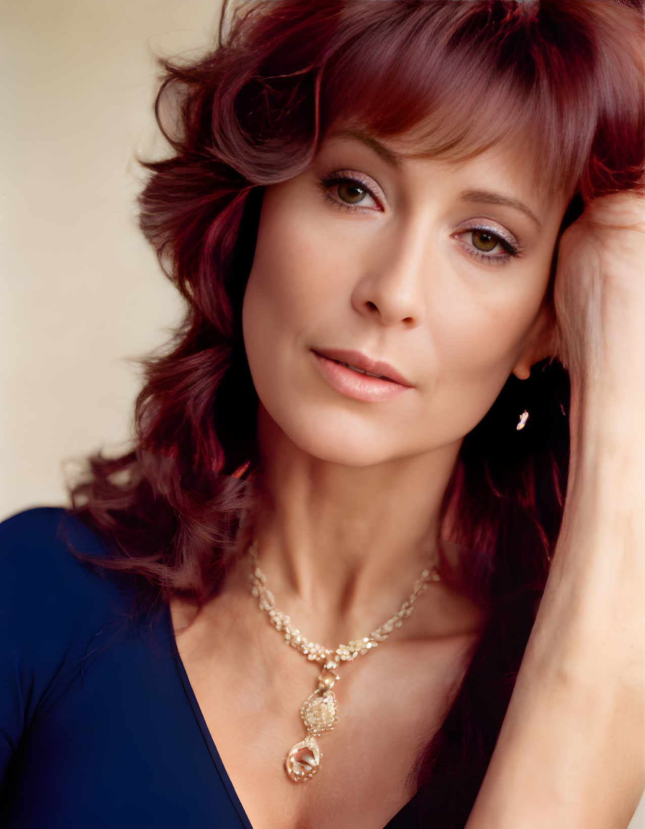 Red-Haired Woman in Blue Top and Gold Necklace Posing Contemplatively