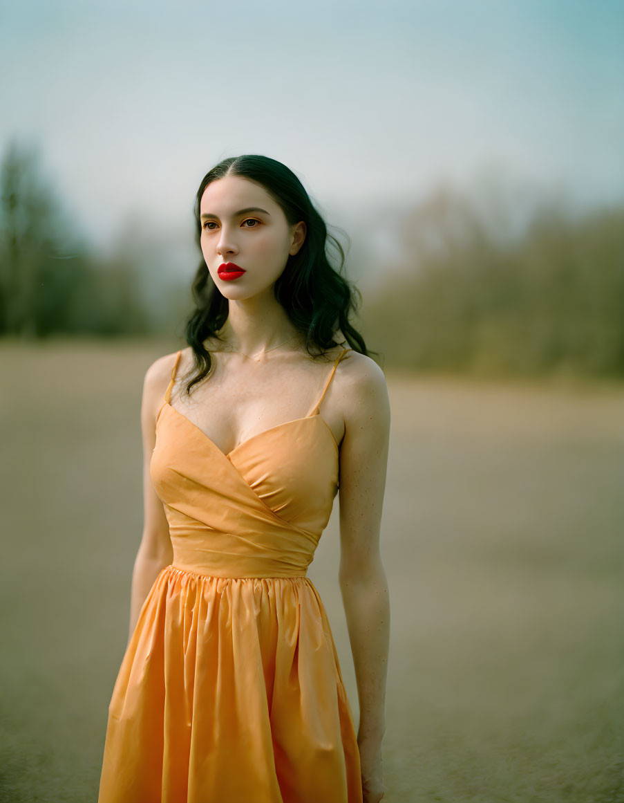 Woman in Orange Dress Outdoors with Dark Hair and Red Lipstick