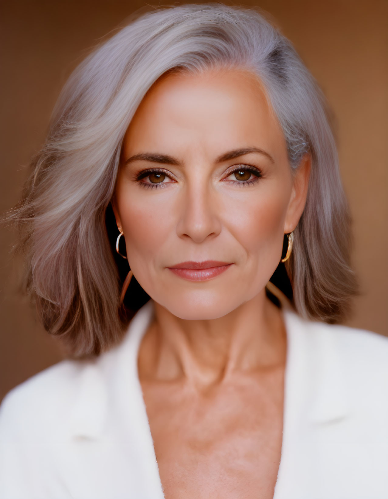 Gray-Haired Woman in White Outfit with Gold Earrings