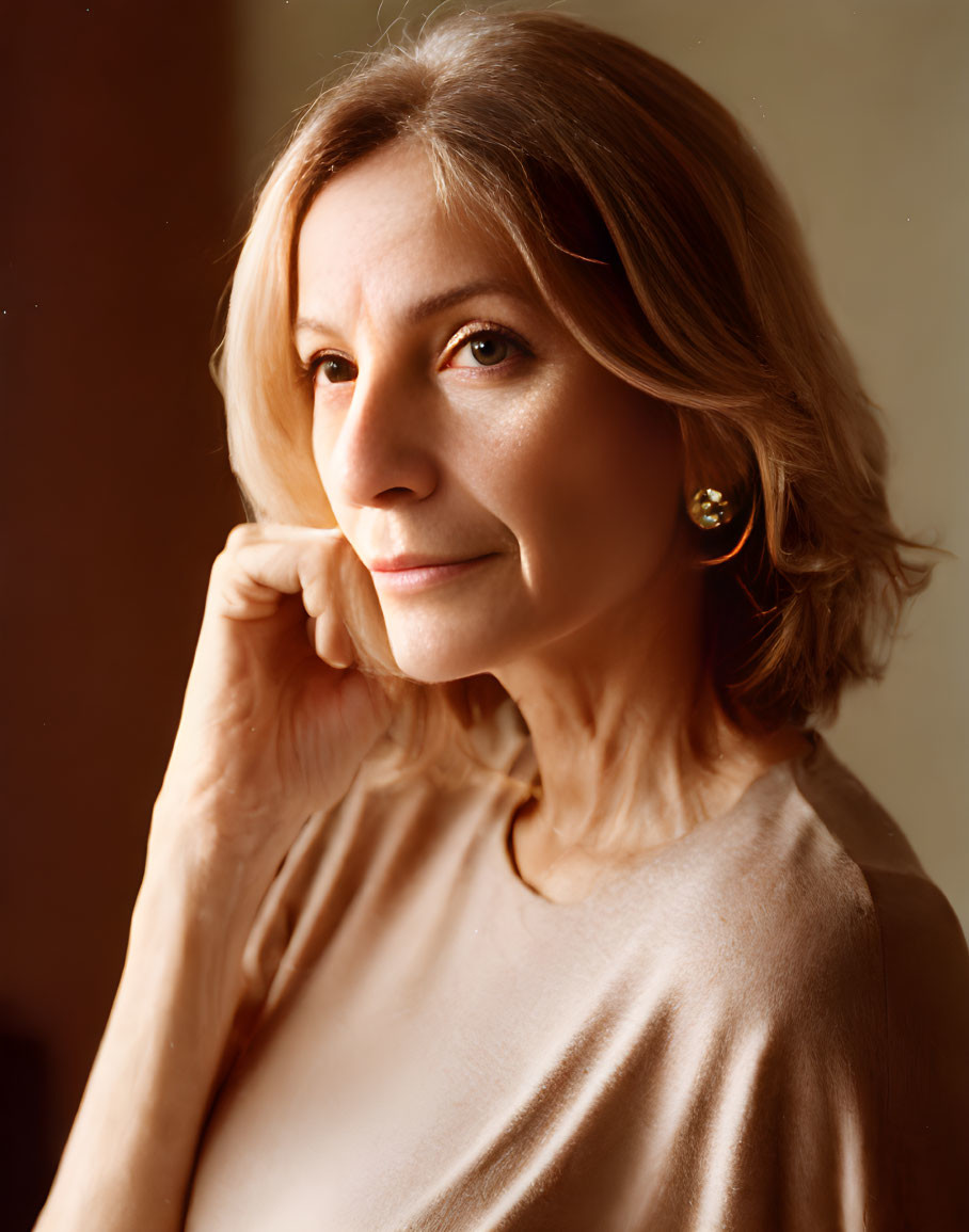 Short-haired woman with earrings in contemplative pose.