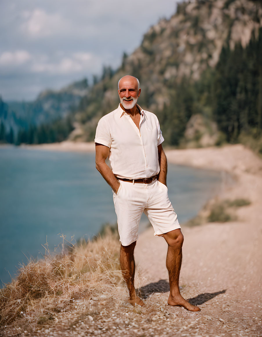 Smiling man in white polo shirt by serene lake