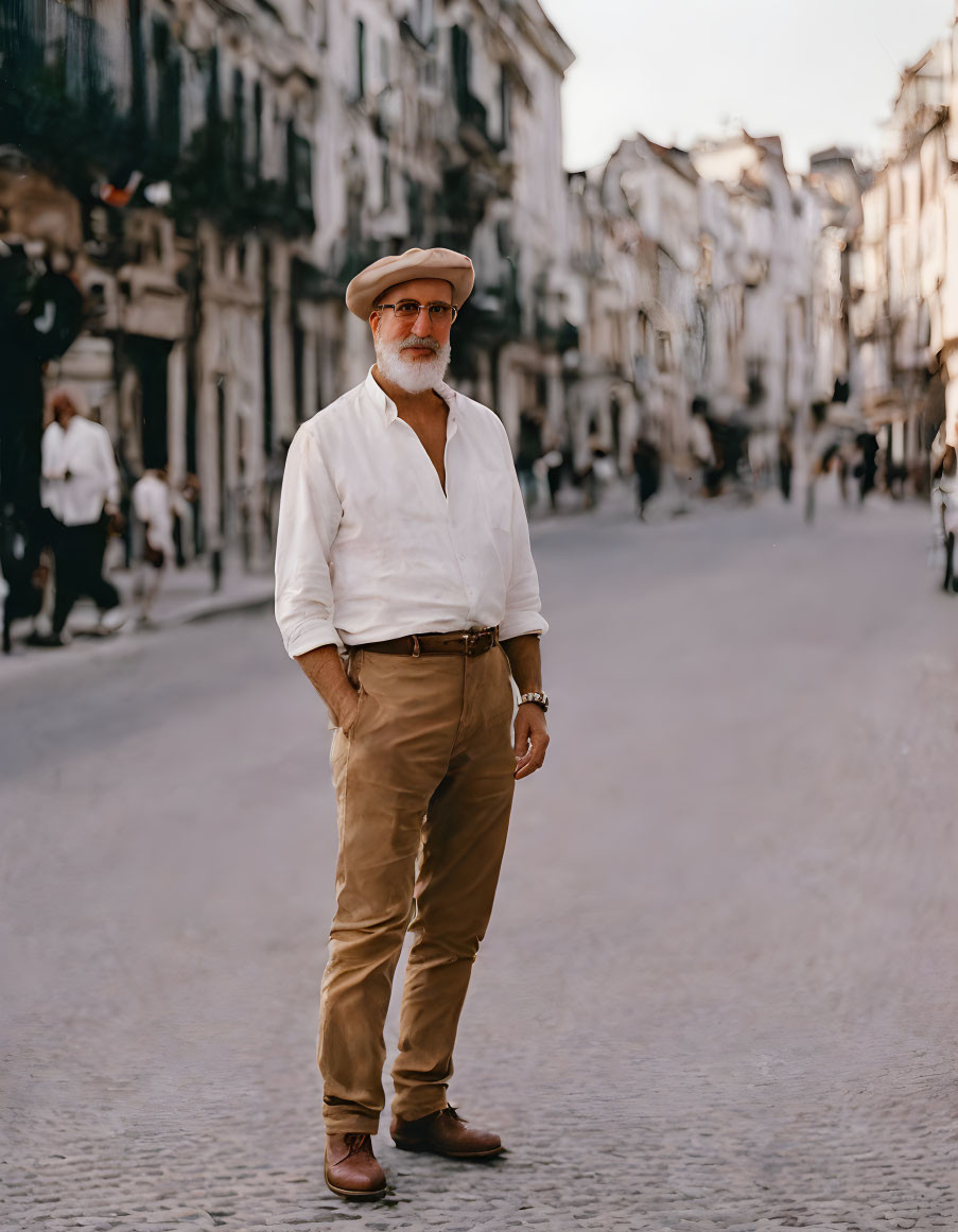 Elegant man in white shirt and hat on cobblestone street