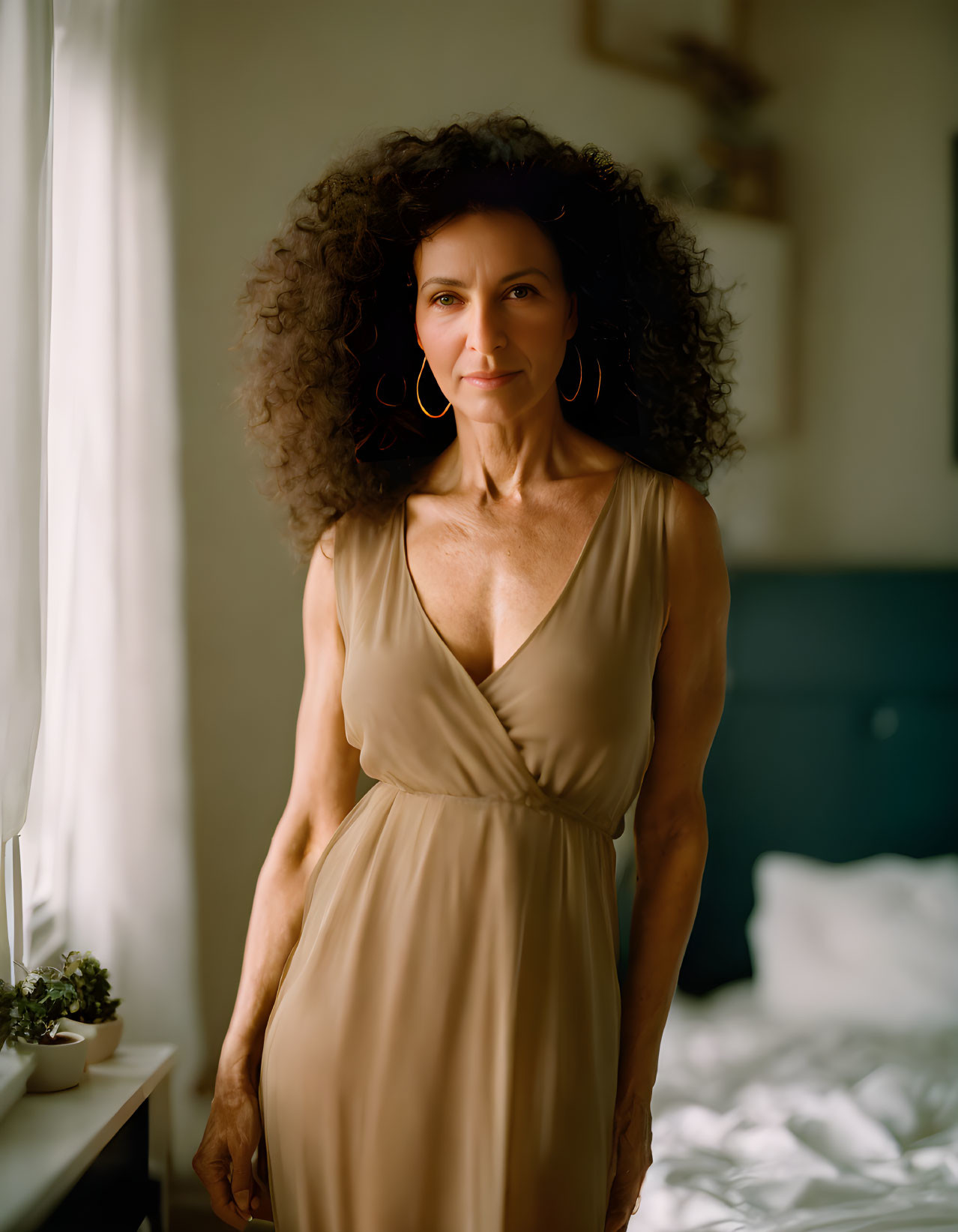 Voluminous Curly Hair Woman in Beige Dress in Sunlit Room