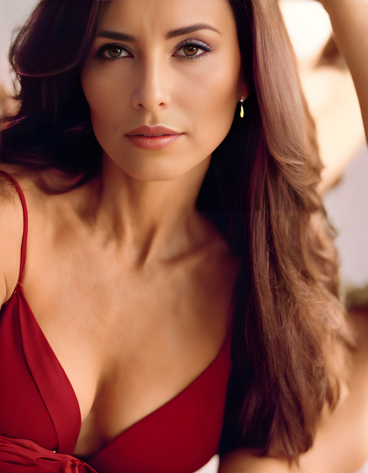 Brunette woman in red dress with thoughtful expression