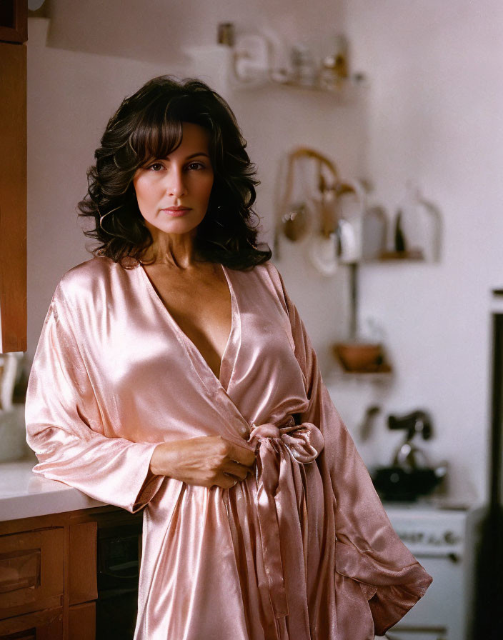 Woman in Pink Silk Robe with Soft Waves Hair in Kitchen