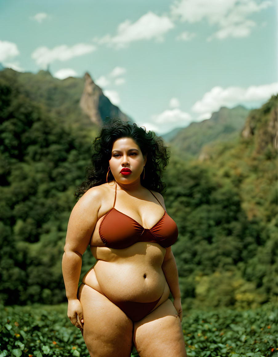 Woman in Brown Bikini Poses in Nature with Mountains and Blue Sky