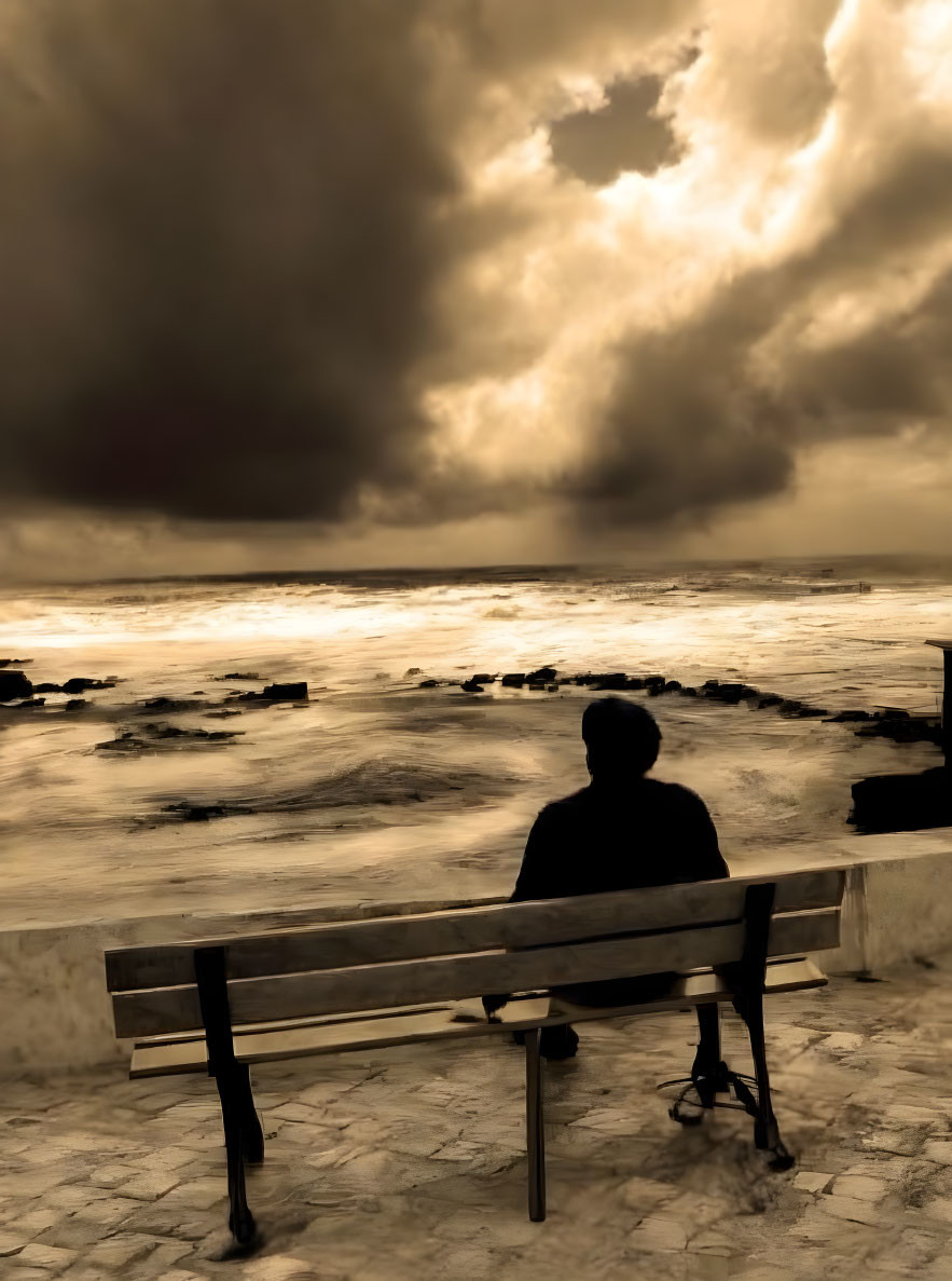 Person sitting on bench by stormy sea under dramatic sky with sun rays.